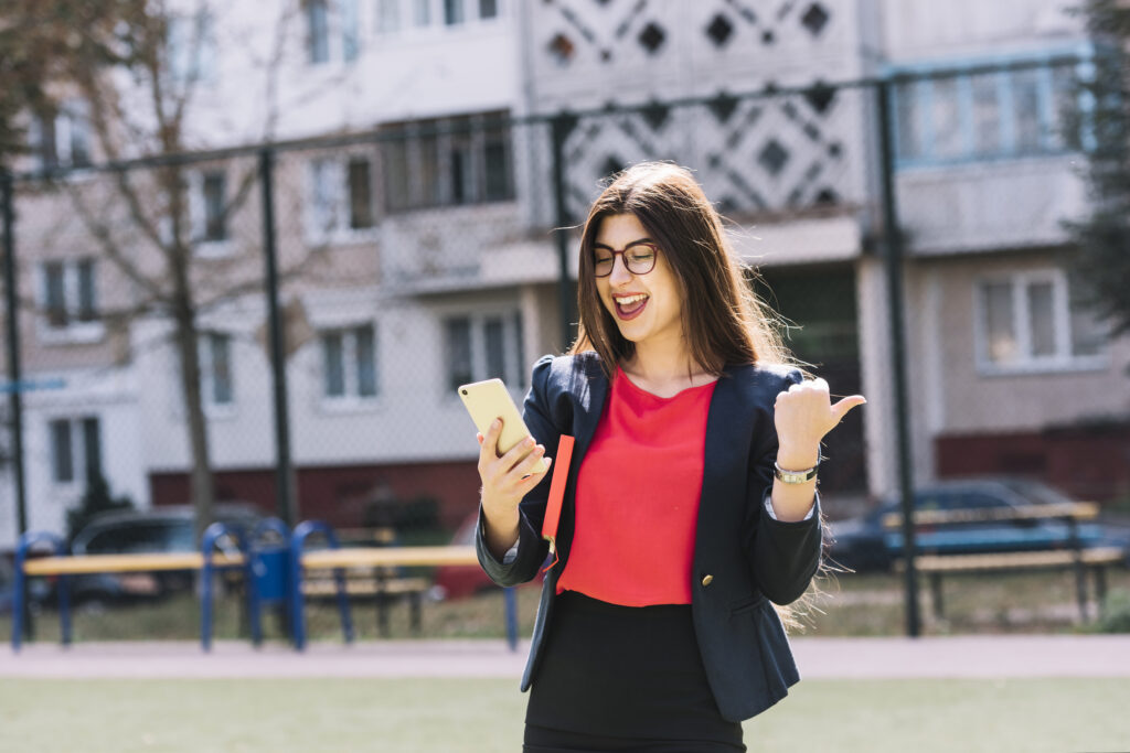 businesswoman-with-smartphone-inside-university-campus